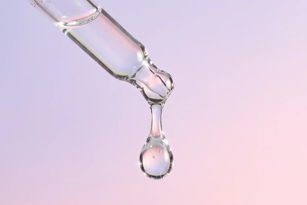 Giọt serum trên đầu ống nhỏ giọt, minh họa nhóm hoạt chất làm đều màu da